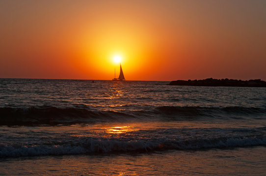 Tel Aviv, Israele: una barca a vela al tramonto sulla spiaggia di Tel Aviv il 31 agosto 2015