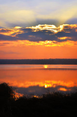 Fototapeta na wymiar Sunrise over the lake early in the morning with beautiful clouds