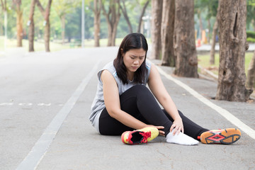 Sports injury. Woman with pain in ankle while jogging