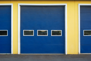 Obraz na płótnie Canvas garage doors blue and yellow front of commercial building