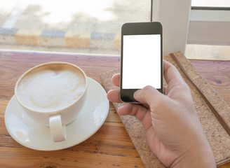 Close up of hands holding cell telephone with blank copy space screen for your advertising text message or promotional content, hipster man watching video on mobile phone during coffee break