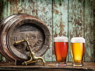 Glasses of  beer and ale barrel on the wooden table. Craft brewe