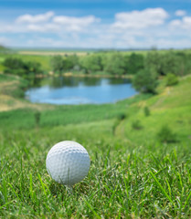 Fototapety  Piłeczka golfowa gotowa do uderzenia na zielonej trawie.