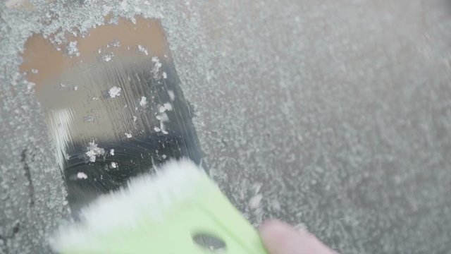 Close up shot of a male hand scraping ice off a cars windscreen. Filmed in super slow motion. Great Winter Background
