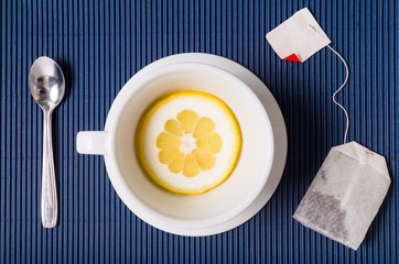 simple composition with tea cup empty but with slice of lemon and a tea bag