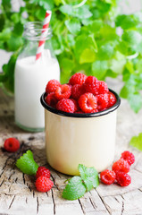 Fresh raspberries in cup and milk