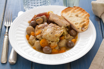 rabbit with mushrooms and carrot on white dish on blue wooden background