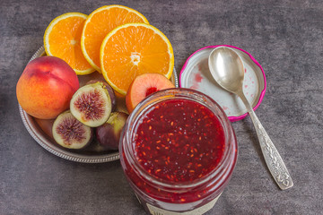Colorful fresh fruits - oranges, figs and peaches on the dark background.