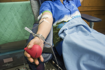 Close up a woman Blood donor at donation and holding a bouncy ball in hand,selective focus,filtered image