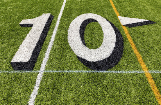 Ten yard line with white lettering on an American football field.