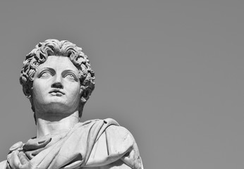 Castor or Pollux with copy space (B/W). Ancient marble statue of Dioskouri at the top of monumental...