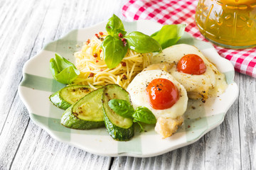 Italian lunch: chicken with mozzarella ,spaghetti and zucchini