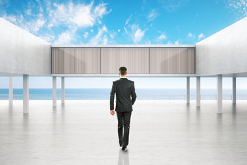 Businessman walking towards concrete exterior