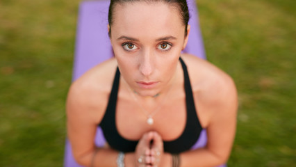 Confident woman meditating with clasped hands