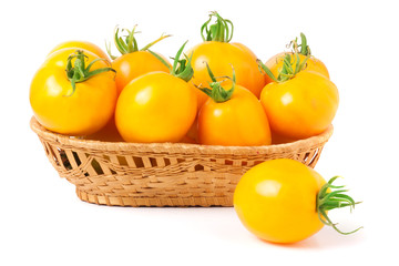 yellow tomatoes in a wicker basket isolated on white background