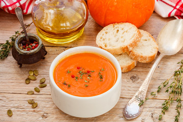 Pumpkin cream soup with thyme and pink pepper. Delicious healthy lunch