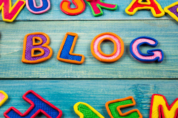 Word BLOG made with plasticine letters on old wooden blue board background. 