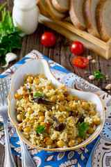 Vegetarian vegetable pilaf chickpea and wild mushrooms on a wood
