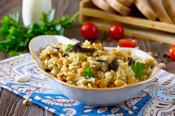 Vegetarian vegetable pilaf chickpea and wild mushrooms on a wood