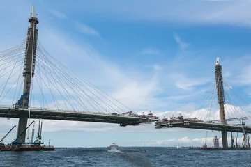 Foto op Plexiglas De bouw van een brug over de rivier. het uitzicht vanaf de © hayoshka