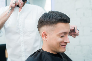 Male Barber Giving Client Haircut In Shop