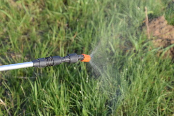 Spraying herbicide from the nozzle of the sprayer manual
