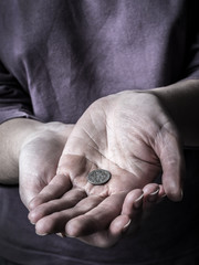 Begging hands holding a coin