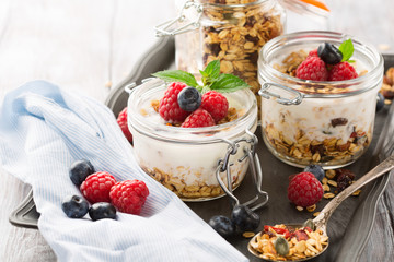 Healthy breakfast - homemade granola and fresh berries, selective focus, rustic wooden table