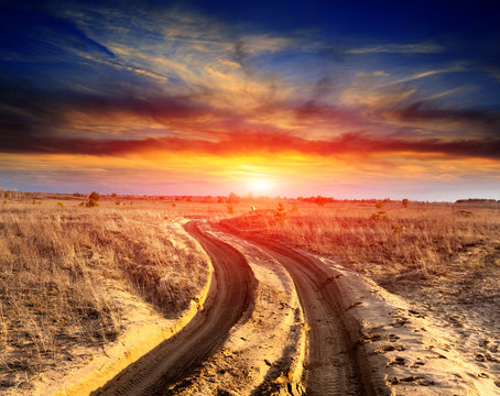 road in sands against sunset background