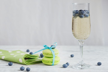Glasses of champagne with blueberries and green macaroons