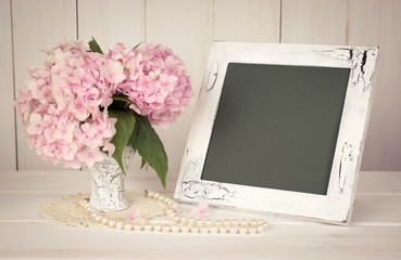 Hortense in retro vase with pearl necklace and photo frame in sh