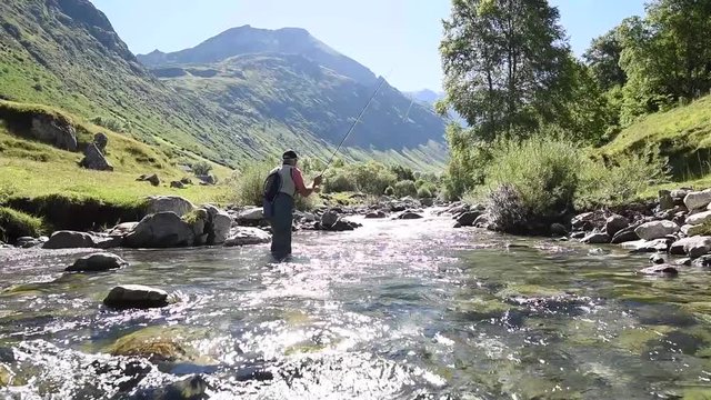 Fisherman fly-fishing in Pyrenees mountain river