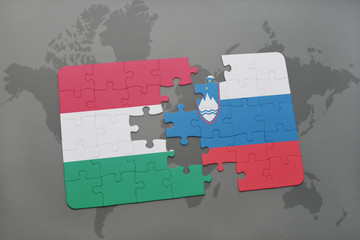 puzzle with the national flag of hungary and slovenia on a world map background.