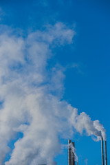 Smoke Stack Emitting Against Sky