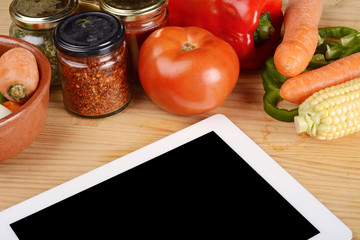 Vegetables and seasonings with a digital tablet.