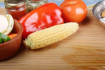 Vegetables and seasonings on wooden table.