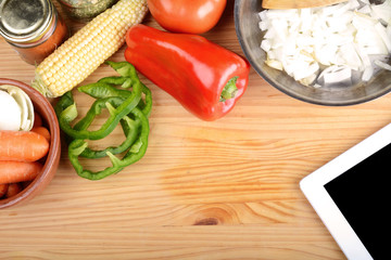 Vegetables and seasonings with a digital tablet.