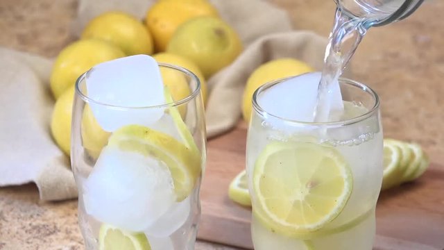 Pouring fresh lemonade into tall glasses
