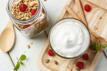 Homemade yogurt or sour cream in a glass on the white wooden tab