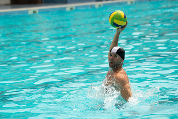 Water polo player attacks the ball with the color of the flag of Brazil - obrazy, fototapety, plakaty