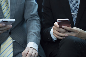 The hands of the young businessmen of two people who have a smartphone