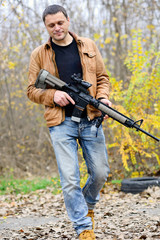 civil man walks with an automatic weapon