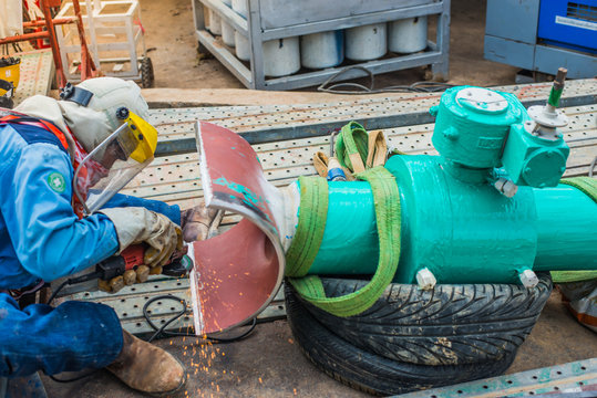 Construction worker welding underground valve gas pipeline