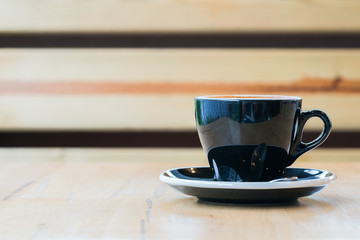 Cup of hot latte art coffee on wooden table

