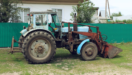 Obraz premium Old excavator near a house in the village