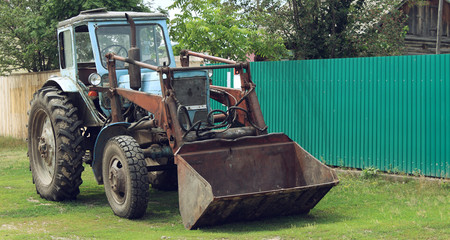 Fototapeta premium Old excavator near a house in the village