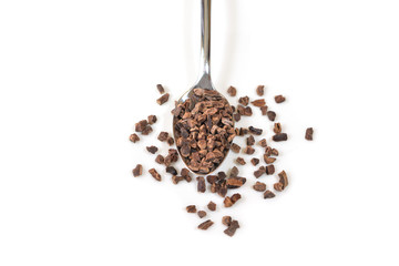 Cacao nibs in a spoon on white background - isolated