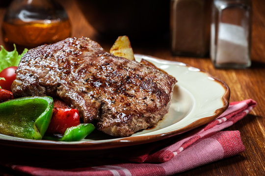 Portions of grilled beef steak with grilled potatoes and paprika