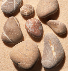 Close up of sea stones on sand. Summer beach background