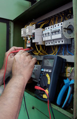A hand of Electrician worker testing industrial machine